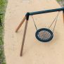 Single Swing (BNS 90cm) ayunan lingkaran dengan rangka kayu dan tali hitam di area bermain anak-anak.