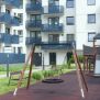 Single Swing (BNS 90cm) ayunan lingkaran dengan rangka kayu dan rantai logam di taman bermain.