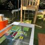 HPL Bench Chess and ludo game dengan papan permainan warna-warni di area bermain luar ruangan.